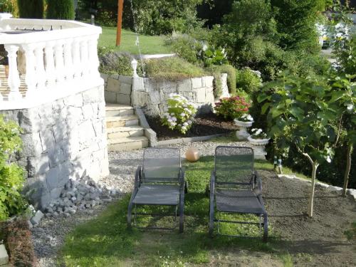 two chairs sitting in the grass in a garden at Regina's Gästehaus in Weisenbach
