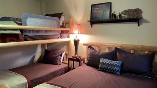 a bedroom with two beds and a lamp on a table at Giant Steps 63 Ski in out in Brian Head