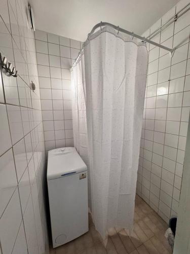 a bathroom with a white shower curtain and a toilet at Northern apartments in Kemi