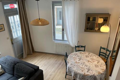 un salon avec un canapé et une table dans l'établissement Charming fisherman's cottage near the station, à Trouville-sur-Mer