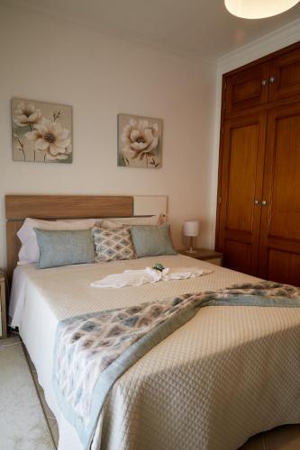 a bedroom with a large bed and two paintings on the wall at Casa Lina T2 in Pêra
