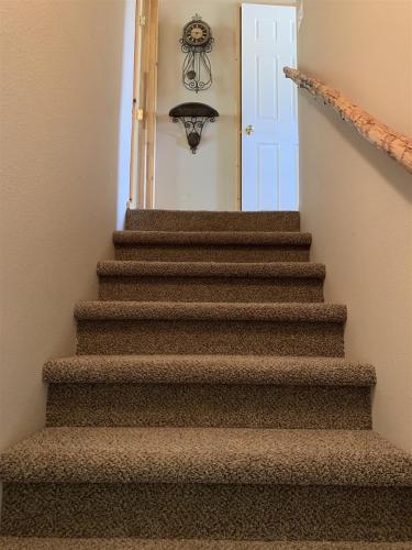 a stairway leading to a white door with a chandelier at Hillside Hideaway in Duck Creek Village