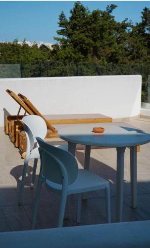 ein blauer Tisch und zwei Stühle auf einem Dach in der Unterkunft Hotel Tagomago in Bucht von San Antonio