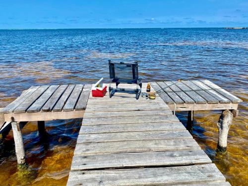 a chair sitting on a dock in the water at Cabaña Cangrejo in Xcalak