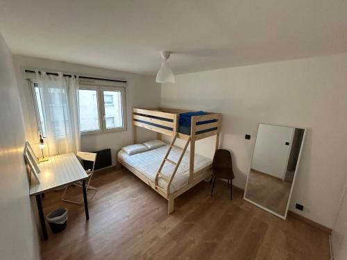 Cette petite chambre comprend des lits superposés et un bureau. dans l'établissement Charmant Appartement à Nancy, à Nancy