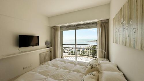 a room with a bed and a window with a view at Depto Varese - Depto Vista al Mar Zona Varese Para 3 PAX Con Cochera - Hola Sur in Mar del Plata