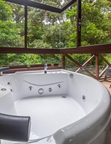 a bath tub sitting in front of a window at Cabañas Refugio Verde Monteverde in Monteverde Costa Rica