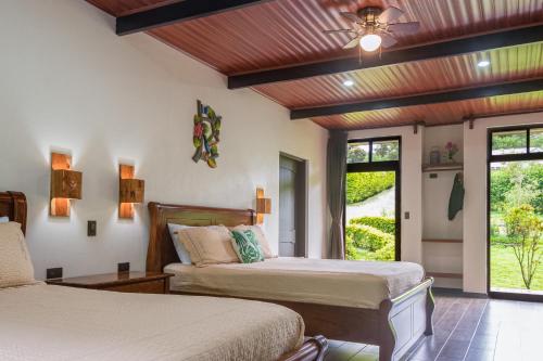 a bedroom with two beds and a ceiling fan at Cabañas Refugio Verde Monteverde in Monteverde Costa Rica