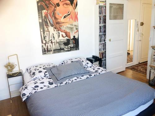 - une chambre avec un lit et une affiche murale dans l'établissement Appartement 3 pièces avec vue 360 sur Paris, à Paris