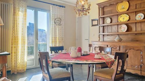 une salle à manger avec une table et des chaises et une fenêtre dans l'établissement Villa Catherine, à Murol