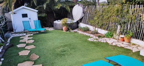 a backyard with blue chairs and a fence at D'art d'art à Sanary in Sanary-sur-Mer