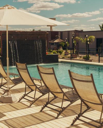 a group of chairs sitting next to a swimming pool at Olivos de Monte in San Miguel del Monte