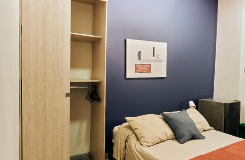 a bedroom with blue walls and a bed with pillows at Apartahotel Poblado-Aguacatala in Envigado