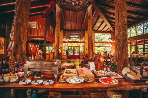 a table with food on it in a restaurant at La Aldea De La Selva Lodge in Puerto Iguazú