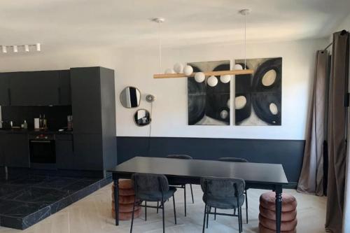 une salle à manger avec une table et des chaises noires dans l'établissement Beautiful T2 center Old Port Festivals, à Cannes