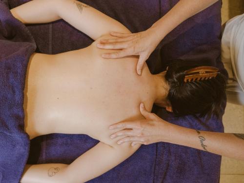 a woman getting her back examined by a massage therapist at Hotellerie De Mascognaz in Champoluc