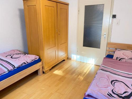 Un dormitorio con dos camas y un armario de madera. en Monteurunterkunft Rottweil, en Rottweil