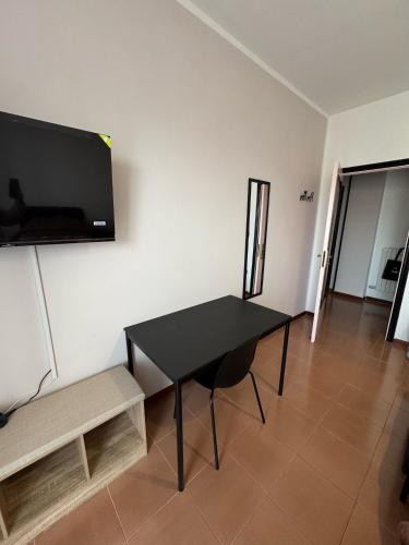 a living room with a black table and a tv on a wall at La Casa Di Gioia in Pagani