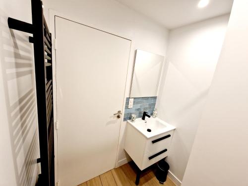 a white bathroom with a sink and a mirror at Studio cosy Proche Lyon Arrivée autonome in Cailloux-sur-Fontaines