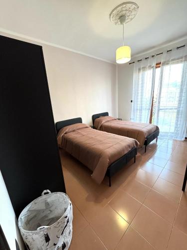 a bedroom with two beds and a chair in it at La Casa Di Gioia in Pagani