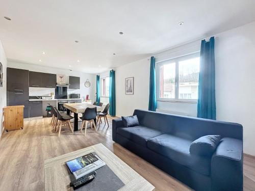 a living room with a blue couch and a table at Apartment 10pers Aubière , Parking, WiFi - TV in Aubière