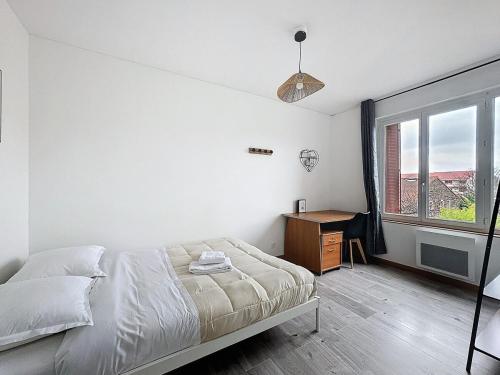 a bedroom with a bed and a desk and a window at Apartment 10pers Aubière , Parking, WiFi - TV in Aubière
