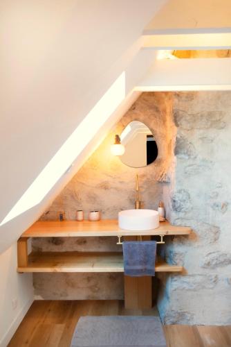 a bathroom with a sink under the stairs at La Maison d'Edouard Spa Chauffé Privé prés du Lac in Lanobre