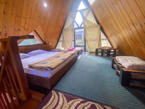 a bedroom with two beds in a wooden cabin at Barrow family cabana in Nuwara Eliya