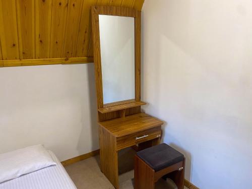 a dressing table with a mirror and a stool at Barrow family cabana in Nuwara Eliya
