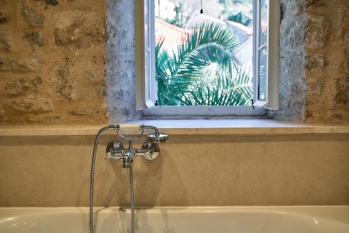 a bath tub with a window in a bathroom at Waterfront Historical Villa Perast in Perast