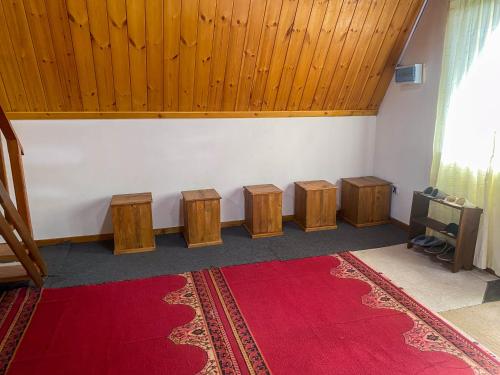 a room with a red rug on the floor and a stage with wooden ceilings at Barrow family cabana in Nuwara Eliya