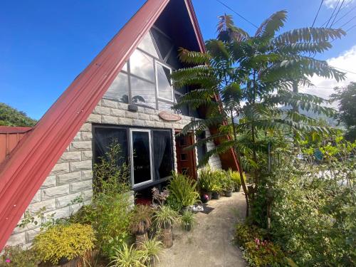 a house with a red roof and some plants at Barrow family cabana in Nuwara Eliya