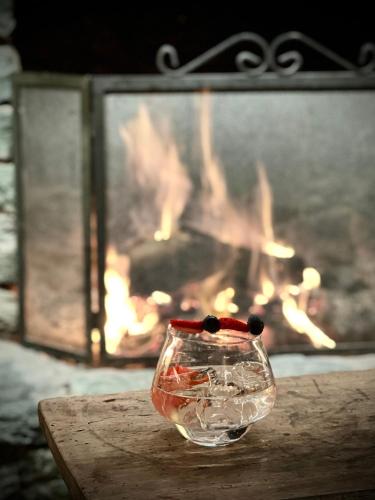 a glass vase sitting on a table with a fireplace at Hotellerie De Mascognaz in Champoluc