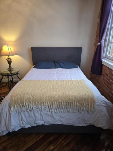 a bedroom with a bed with a white bedspread and a window at Detroit Artsy Industrial Loft in Detroit
