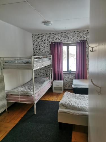 a room with two bunk beds and a window at Guldklimpens Vandrarhem in Gunnarn