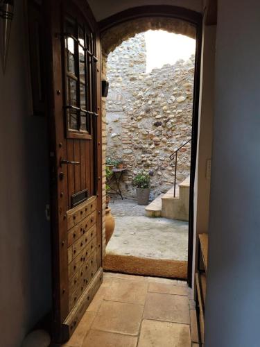 une porte ouverte menant à une chambre dotée d'un mur en pierre. dans l'établissement La Barrade - Atypical House, à Cagnes-sur-Mer