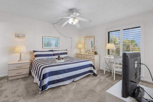 une chambre avec un lit et un bureau avec une télévision dans l'établissement Lake Access, Community Pool, Tennis & Pickleball -Condo Lagoon Landing -Roelens, à Fort Myers Beach