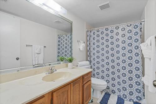 une salle de bain avec un lavabo, des toilettes et un miroir dans l'établissement Lake Access, Community Pool, Tennis & Pickleball -Condo Lagoon Landing -Roelens, à Fort Myers Beach