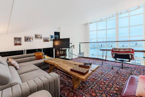a living room with a couch and a table at London Canary Wharf Riverside Penthouse Apartment in London