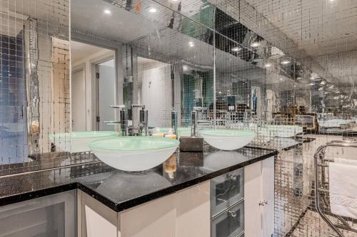 a bathroom with two sinks and a large mirror at London Canary Wharf Riverside Penthouse Apartment in London
