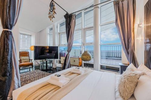 a bedroom with a bed and a large window at London Canary Wharf Riverside Penthouse Apartment in London