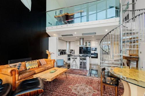 a living room with a couch and a table at London Canary Wharf Riverside Penthouse Apartment in London