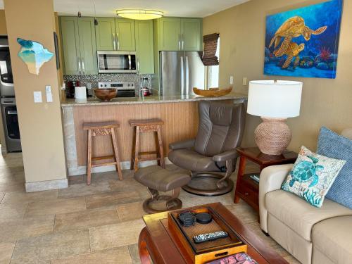 a living room with a couch and a kitchen at Exceptional Kona Reef Condo - Full AC - Oceanfront - Walking Distance to Restaurants & Shops in Kailua-Kona