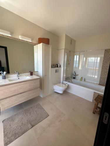 une salle de bain avec un lavabo, des toilettes et une baignoire dans l'établissement Appartement de standing, vue mer, 3 chambres, à Ajaccio