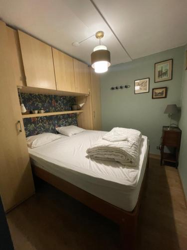 a bedroom with a large bed with white sheets at La Corneille en Mer in Ostend