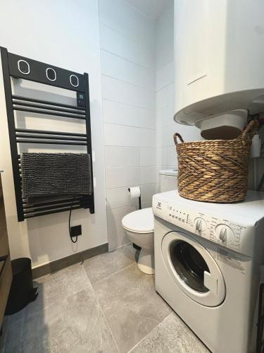 a bathroom with a washing machine and a toilet at Le Cocon - Studio Chaleureux in Cholet