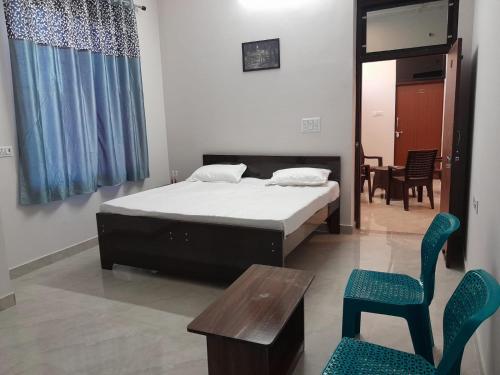 a bedroom with a bed and a table and chairs at Riya Home Stay in Sawāi Mādhopur