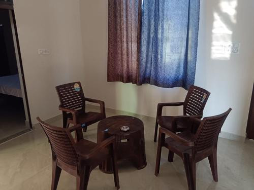 a room with three chairs and a table and a window at Riya Home Stay in Sawāi Mādhopur