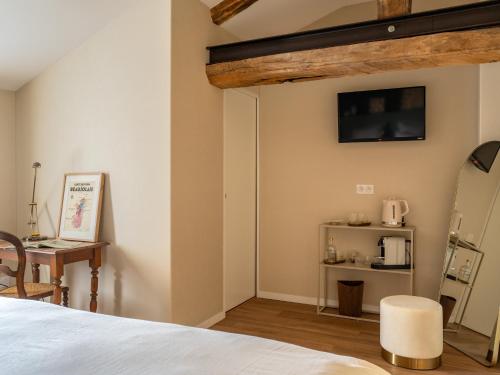a room with a bed and a table and a microwave at Le Pavillon des Capitans in Juliénas