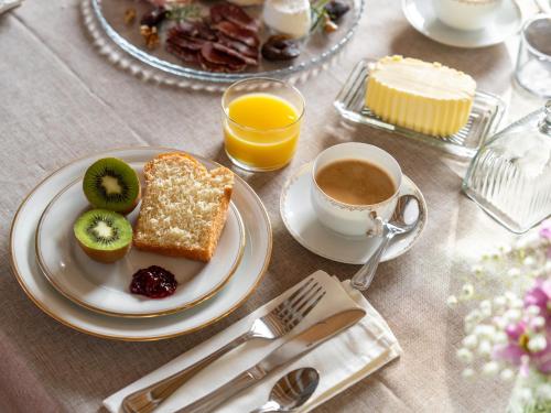 a table with a plate of food and a cup of coffee at Le Pavillon des Capitans in Juliénas